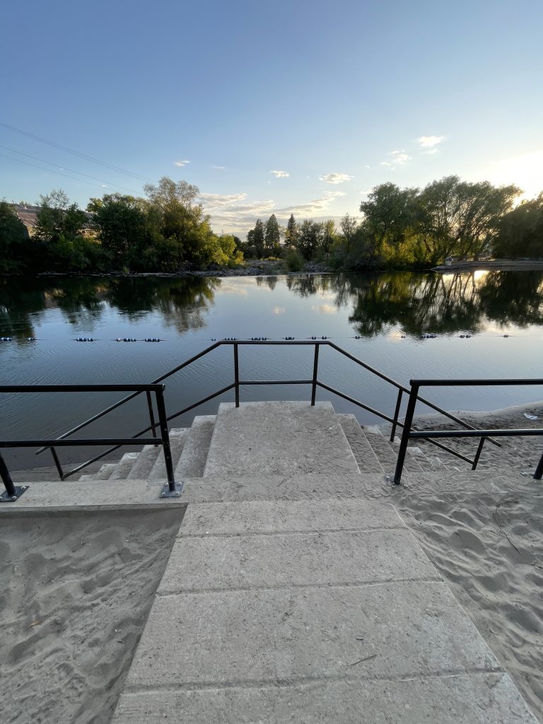 Sand Play area and two starins with the river at sunset in the background.