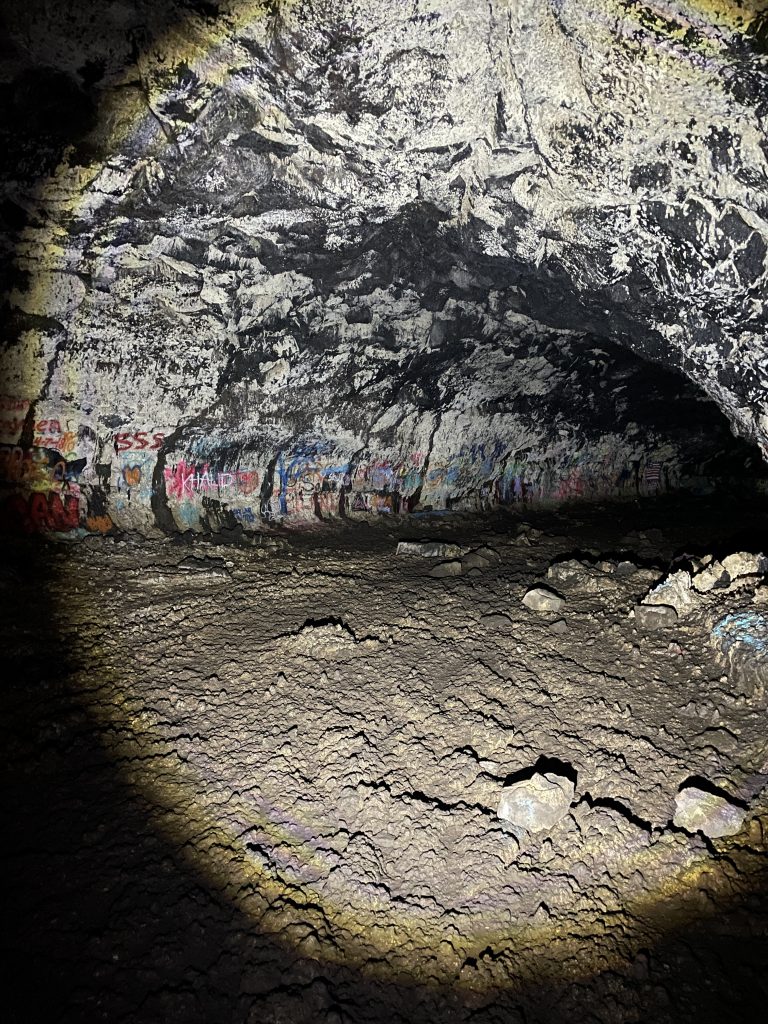 Inside the Civil Defense Cave showing the lava tube with graphiti on the walls.