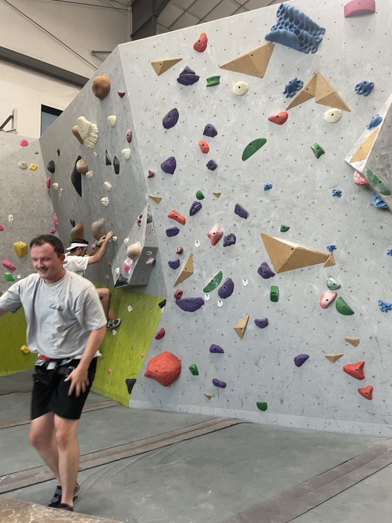My freind enjoying his time at the Rock Climbing Gym in front of the boulder wall.