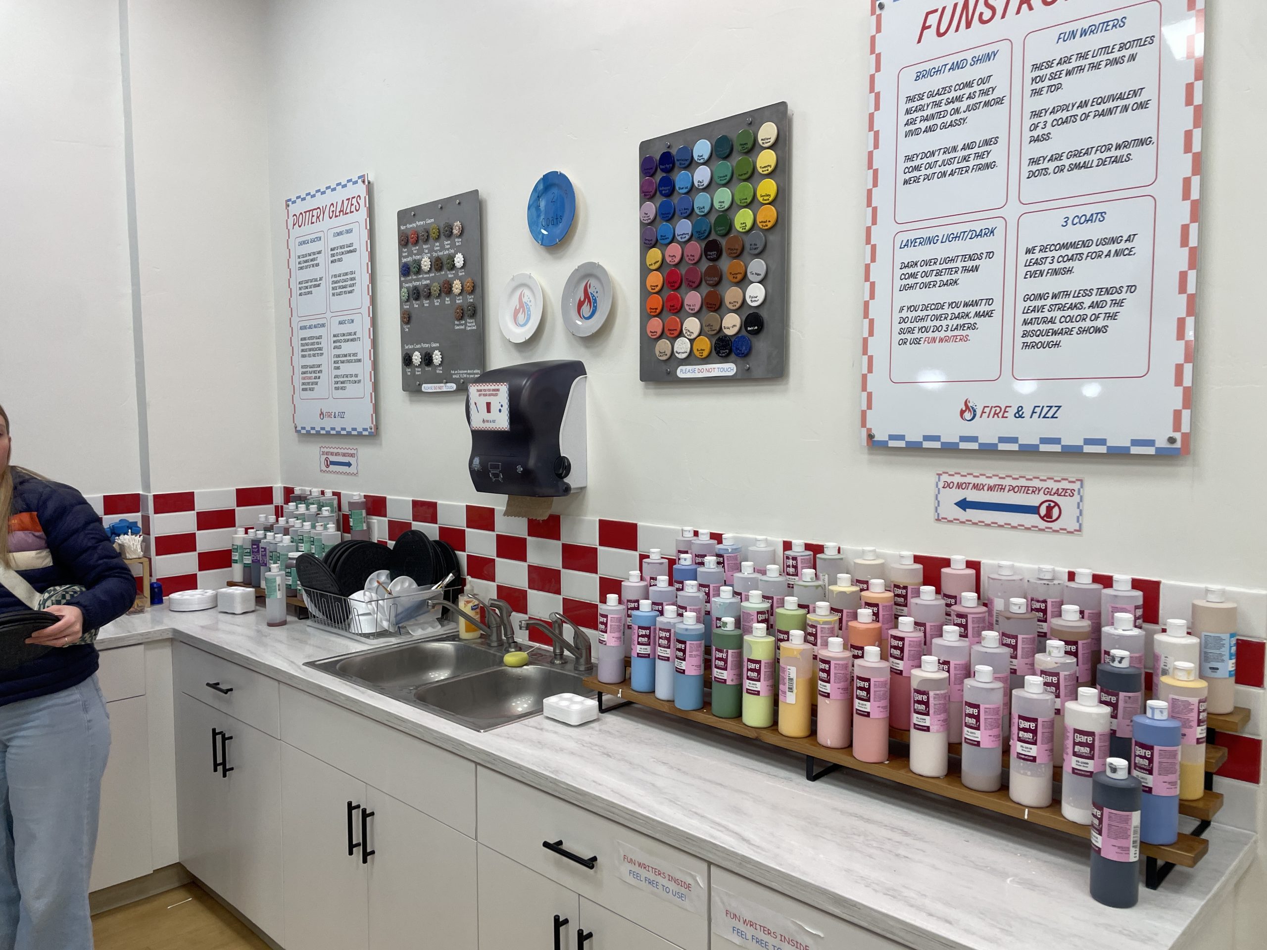 Bunch of different paint colors to paint pottery on white cabinets.